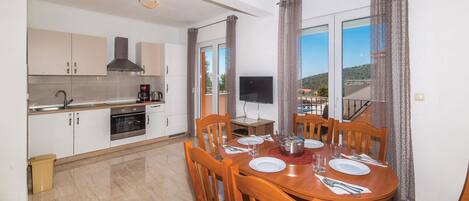 Enjoy a meal at the dining table, set with a wooden table and chairs, while taking in the view from the large window.