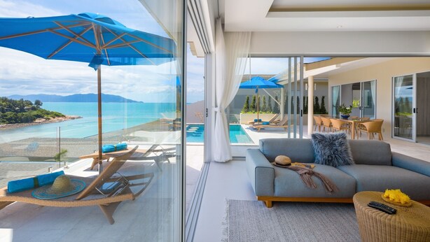 Ein modernes Wohnzimmer mit einer großen Glaswand, einem Sofa, einem Couchtisch und einem blauen Regenschirm.