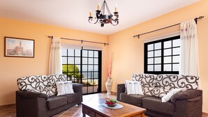 A living room with two sofas, a coffee table, and a chandelier. - Finca Vinco with heateble Pool (Alcalá)