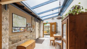 Un intérieur chaleureux avec un mur en pierre, un banc en bois, une carte et un meuble en bois.