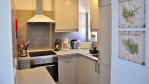 Uma cozinha moderna com eletrodomésticos de aço inoxidável, forno embutido e cafeteira.