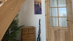 A wooden staircase leading to a landing with a wooden door and a window.