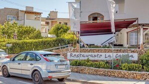 A white car parked in front of a building with a sign reading 'Restaurante La Casa.'
