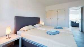 Ein Hotelzimmer mit Bett, Nachttisch, Lampe und Kleiderschrank.