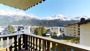 Un balcone con vista su una catena montuosa e un lago.