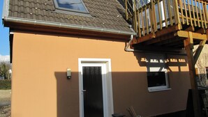 Ein zweistöckiges Haus mit Balkon, Fenster und Tür.