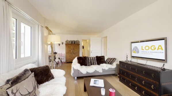 A modern living room with a sofa, a coffee table, a TV, and a wooden cabinet.