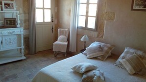 A bedroom with a bed, a chair, a lamp, and a dresser. - Le Mazet Jean. Camargue Bed and Breakfast (kindling) (Le Cailar)