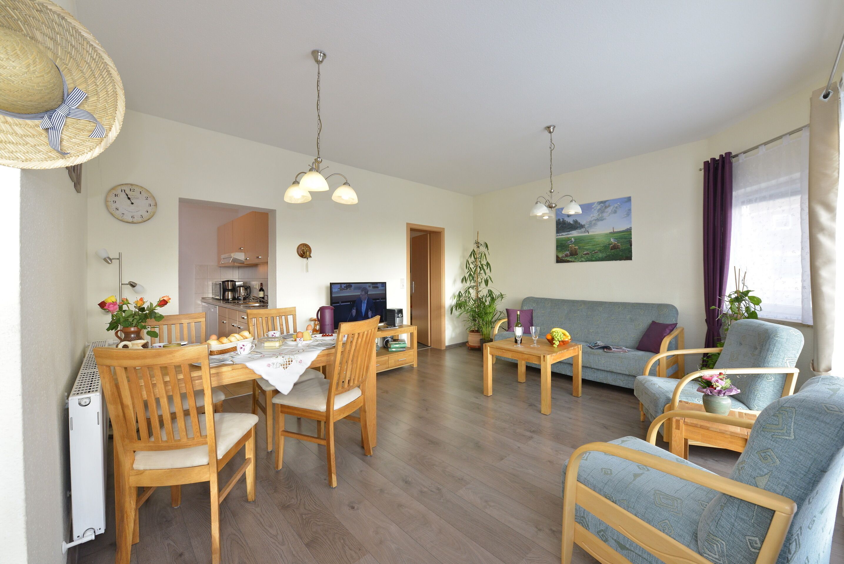 Ein gemütliches Wohnzimmer mit Essbereich, Holzmöbeln und Blick zur Küche.