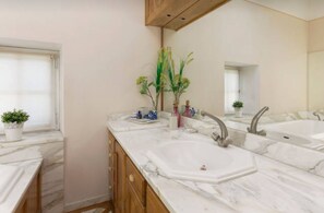 Een bad/douchecombinatie, een haardroger, handdoeken, zeep