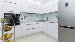 A modern kitchen with white cabinetry, a stainless steel refrigerator, a built-in oven, and a coffee maker. - 3 bedroom luxurious home in Grizane (Grizane)