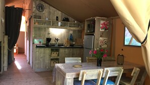A wooden interior with a kitchen area, dining table, chairs, and a clock on the wall. - Cottage 5p comfort in beautiful area with pool (le buisson de cadouin)