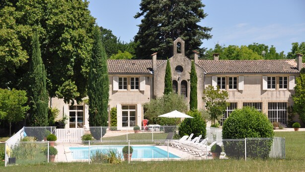 A large building with a swimming pool, surrounded by a fence, and featuring a bell tower. - La Petite Maison, 14 p., at the beautiful “Domaine de Vincenti » (Domaine de Vincenti Divajeu)