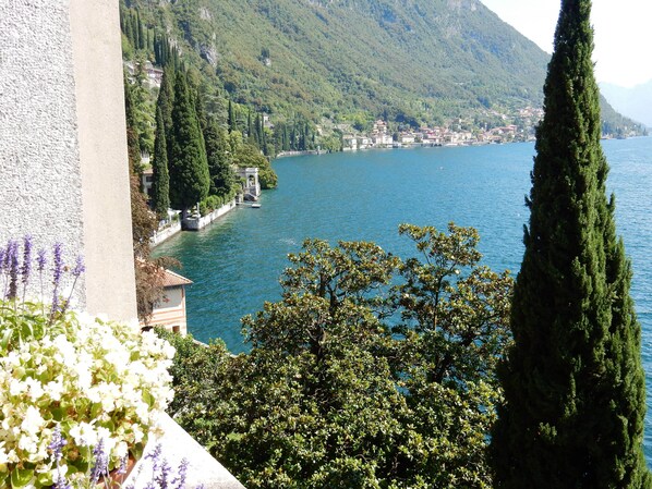A coastal town with a view of the sea, surrounded by greenery and hills.
