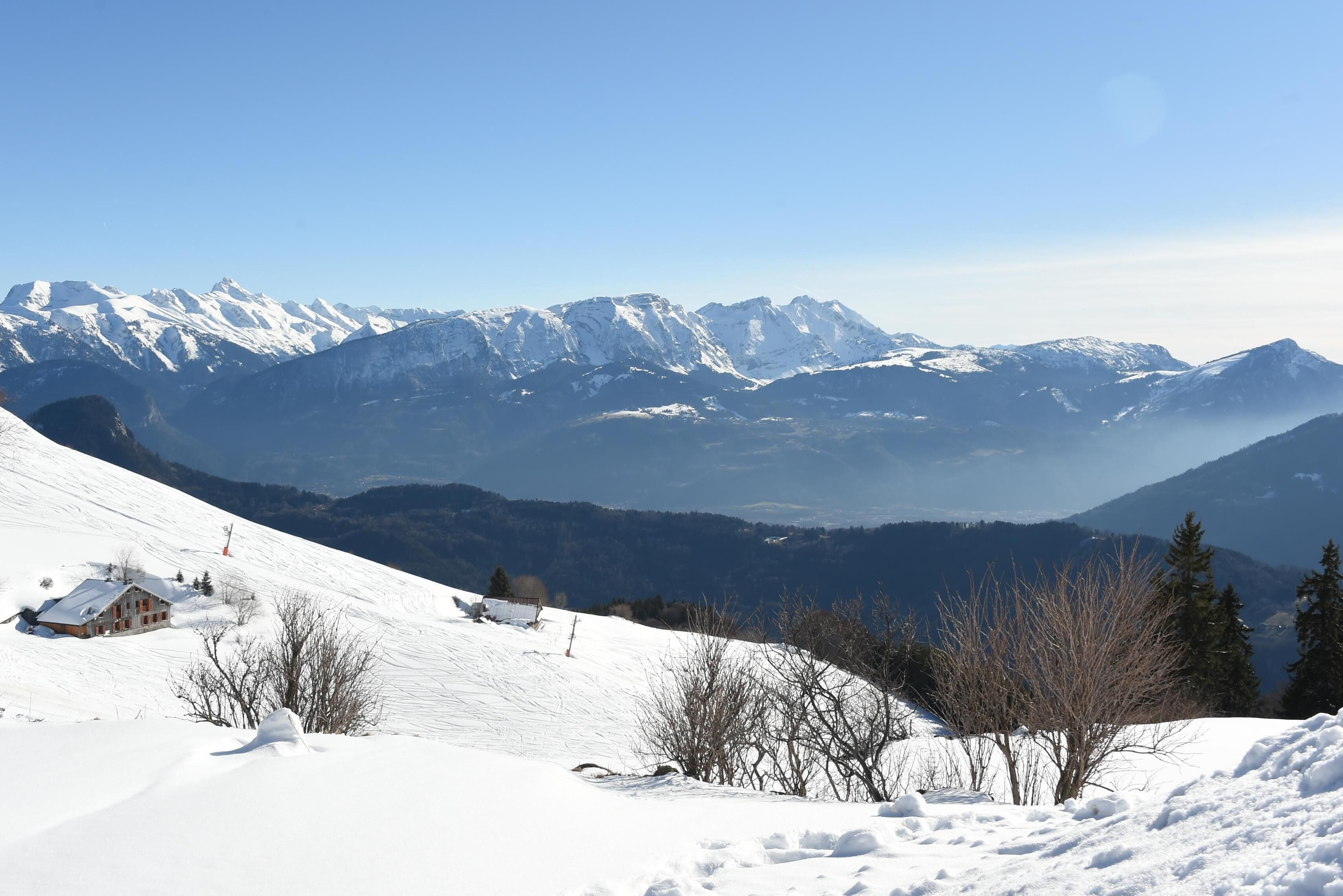A snow-covered mountain landscape with a chalet and a ski lift.