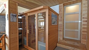 Una cabaña de madera con sauna, un calendario y un cartel con vistas a la montaña.