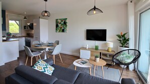 Un espace de vie moderne comprenant un coin repas, une cuisine et un coin salon.