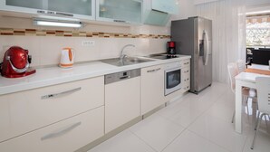 A modern kitchen with a built-in oven, dishwasher, and a refrigerator. - Villa with private swim pool, 40 meters from the sea (Seget Vranjica)