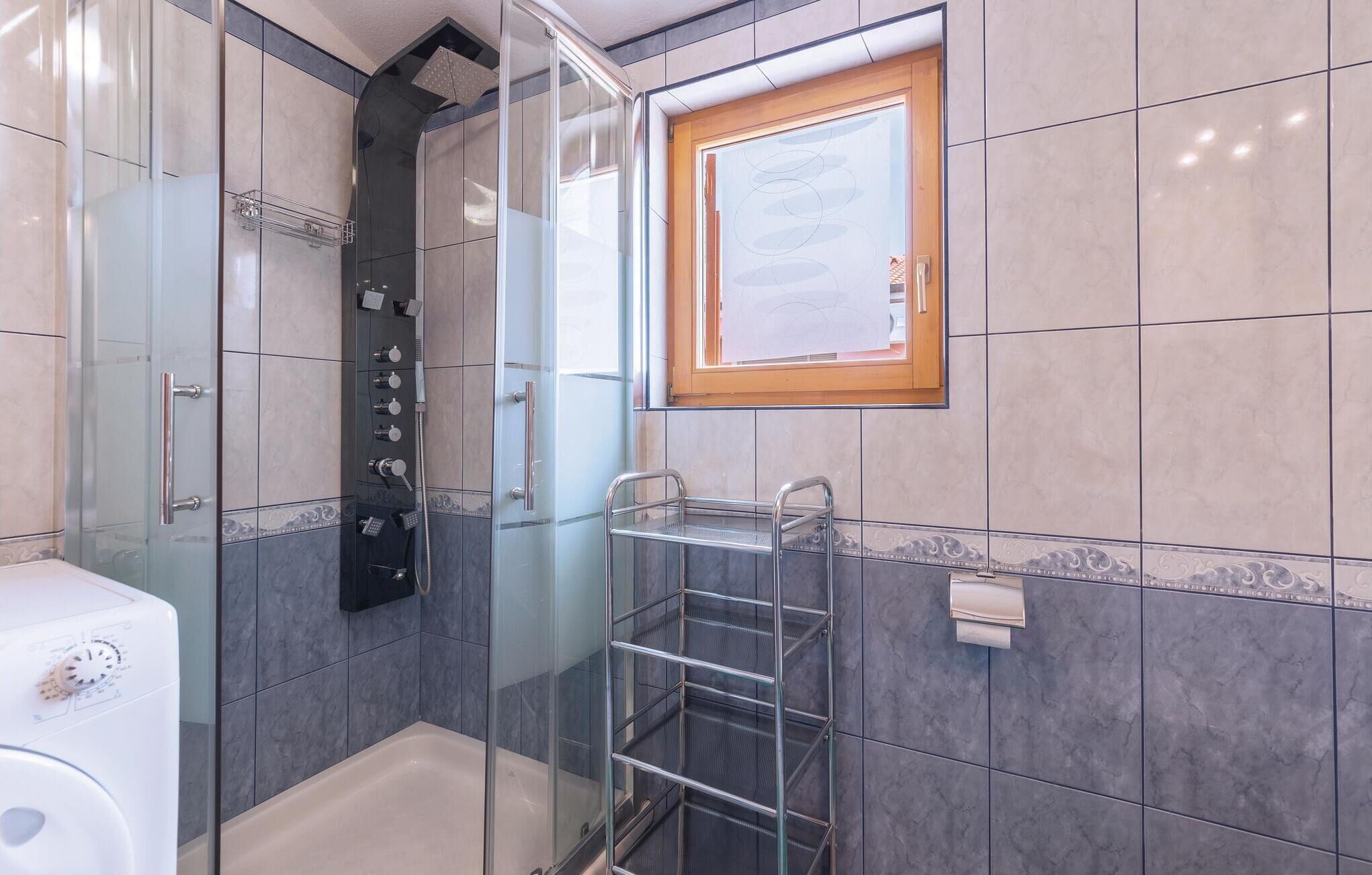 A modern bathroom with a glass-enclosed shower, a built-in toilet, and a towel rack.