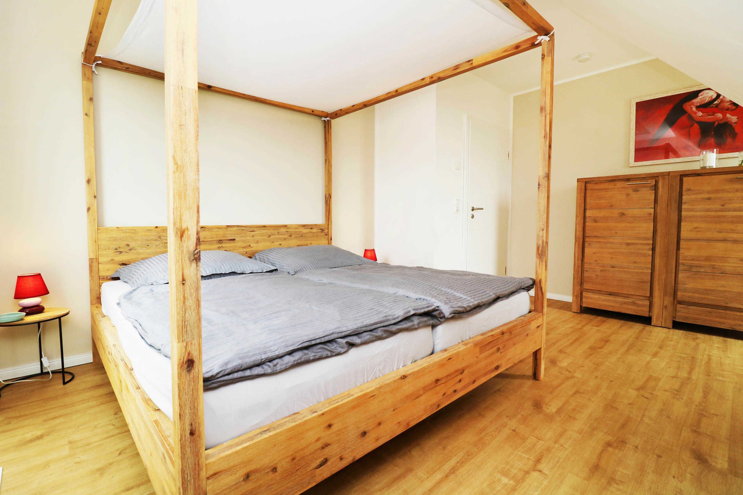 Schlafzimmer im Ferienhaus Hinnerk in Karlshagen auf der Insel Usedom mit Doppelbett und hellen Holzmöbeln.