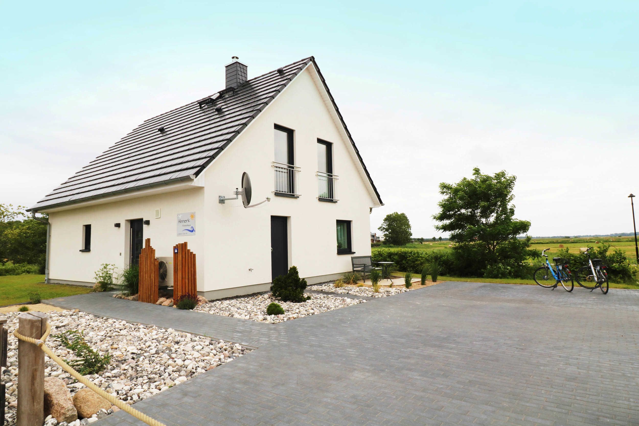 A single-story building with a sloped roof, a small porch, and a paved driveway.
