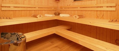 Uma sala de sauna com paredes, bancos e janela de madeira.
