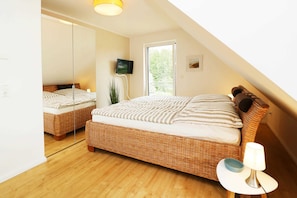 Schlafzimmer im Ferienhaus Hinnerk in Karlshagen auf der Insel Usedom mit Doppelbett und Dachfenster.