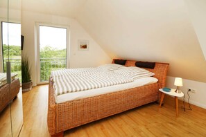Schlafzimmer im Ferienhaus Hinnerk in Karlshagen auf der Insel Usedom mit Doppelbett und Fenster.