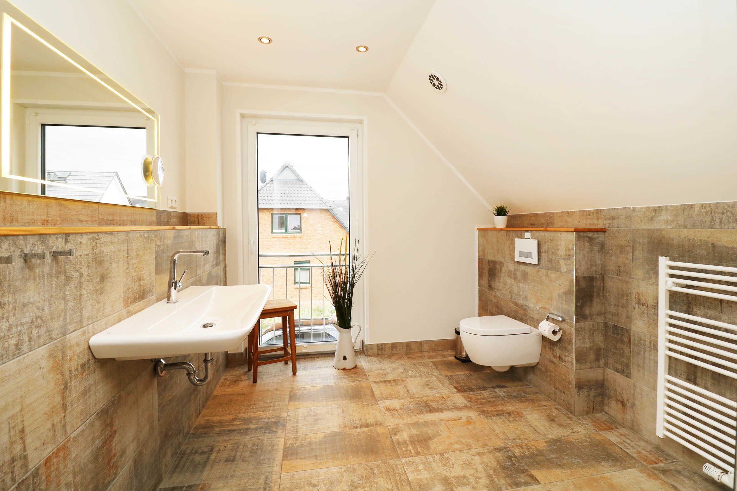 Une salle de bain moderne avec un lavabo sur pied, des toilettes et un espace douche.
