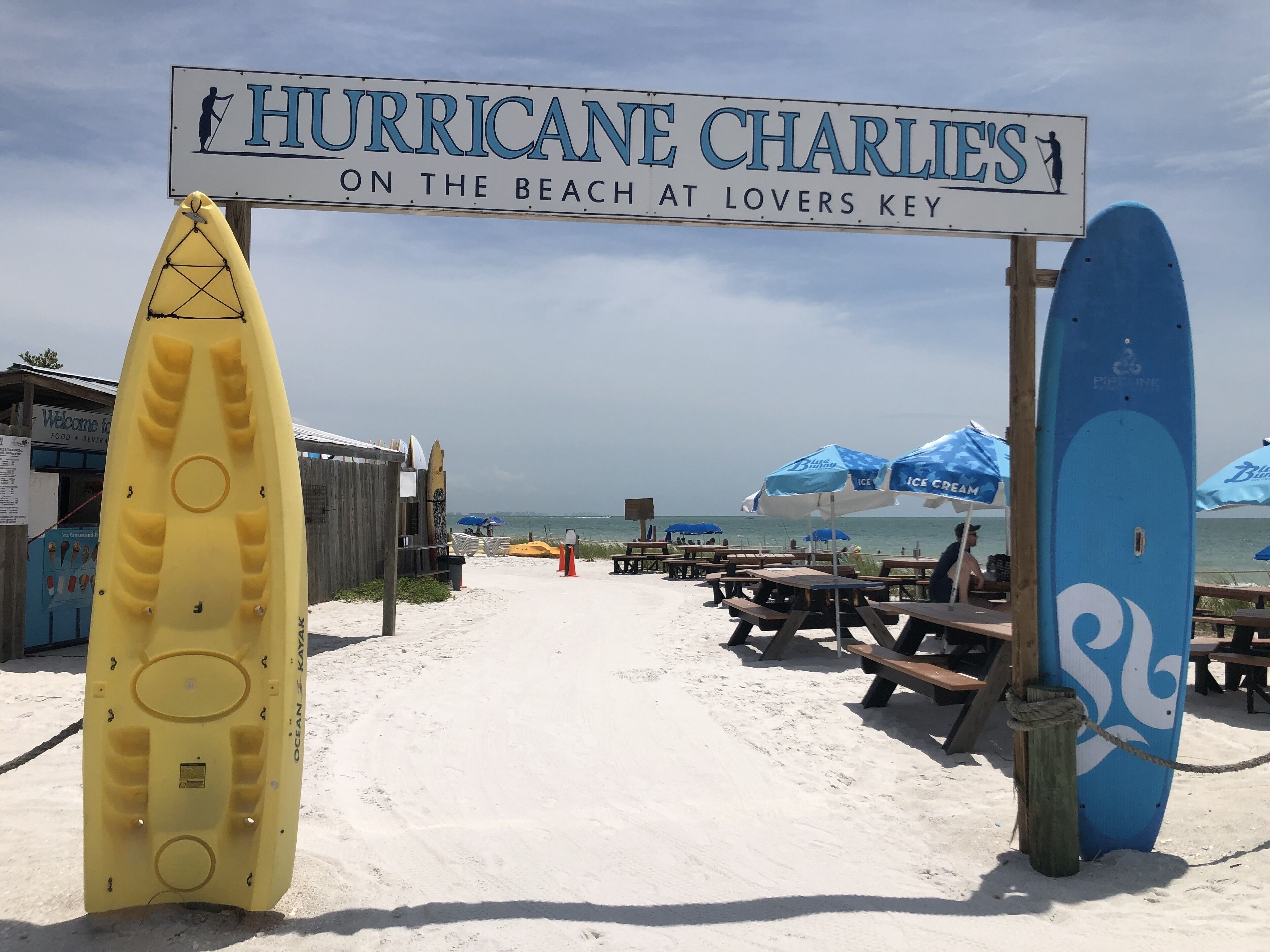 Una entrada a la playa con un letrero que dice "HURRICANE CHARLIE'S ON THE BEACH AT LOVERS KEY".