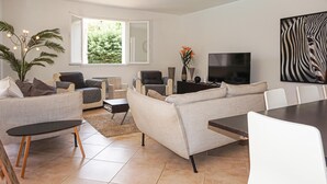 A modern living room with a sofa set, a coffee table, a dining table, and a TV. - Pet friendly home in Bédarieux (Bédarieux)