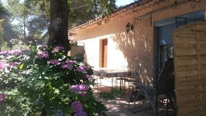 A rustic building with a tiled roof, a wooden door, and a table with chairs outside. - Comfortable gîte in the heart of the quiet luberon countryside, ideal for families. (Bonnieux)