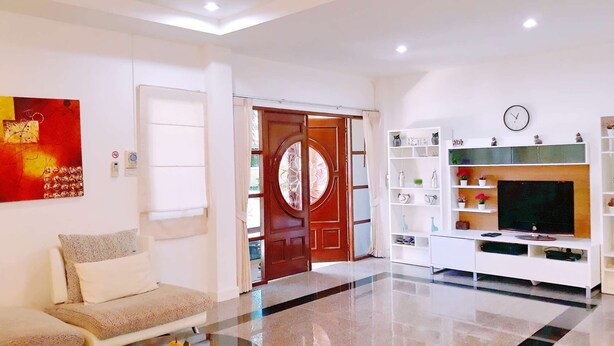 Una sala de estar moderna con un sofá, un televisor y una estantería.