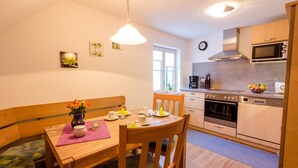 Una cocina compacta con comedor, muebles de madera y una ventana.