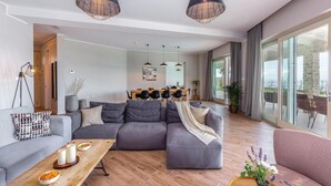 A modern living room with a sectional sofa, a wooden coffee table, and pendant lighting. - Amazing home in Veprinac with sauna (Veprinac)