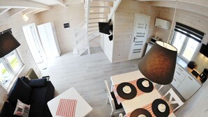 A modern interior with a staircase, a dining area with a table and chairs, and a kitchen area with cabinets and appliances. - The newly built "White Cottage Lux", Grzybowo in Um Kolberg, 1-6 persons (Grzybowo)
