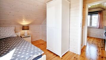Una camera da letto con un letto, un comodino, una lampada e un armadio.