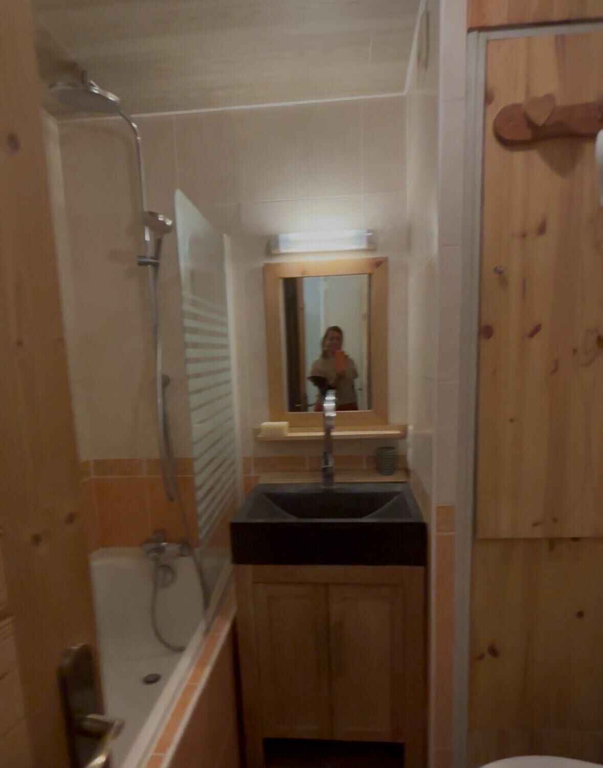 A bathroom with a shower, a sink, and a mirror.