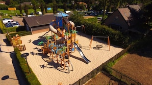 A playground with a slide, swings, and climbing structures. - Group farm for 20 people (Voorthuizen)