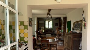Una cocina amplia con comedor, que incluye una mesa grande, sillas y una araña.