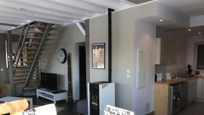 A modern kitchen with a dishwasher, a sink, and a stove. There is a staircase leading to an upper level. - The clock Chalain 2 (Doucier)