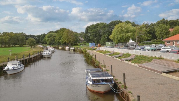 A canal with boats docked on the left, a pedestrian walkway on the right, and a parking area with cars. - 1 bedroom cozy apartment in Varde (Varde)