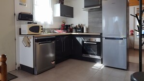 Una cocina compacta equipada con lavavajillas, microondas, horno y refrigerador.