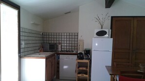 Eine kleine Küche mit Geschirrspüler, Mikrowelle und Kühlschrank.