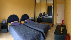 A room with two beds, a mirror, a nightstand, and a small table with a candle. - Bright, quiet and centrally located apartment with balcony and air conditioning (Nice)