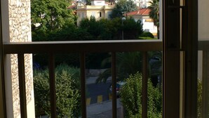 A balcony with a view of a residential area, including houses and a mountain in the distance. - Bright, quiet and centrally located apartment with balcony and air conditioning (Nice)