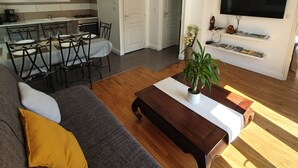 Ein modernes Wohnzimmer mit Sofa, Couchtisch und Essbereich.