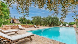 Ein Pool mit Steinböden und Liegestühlen.