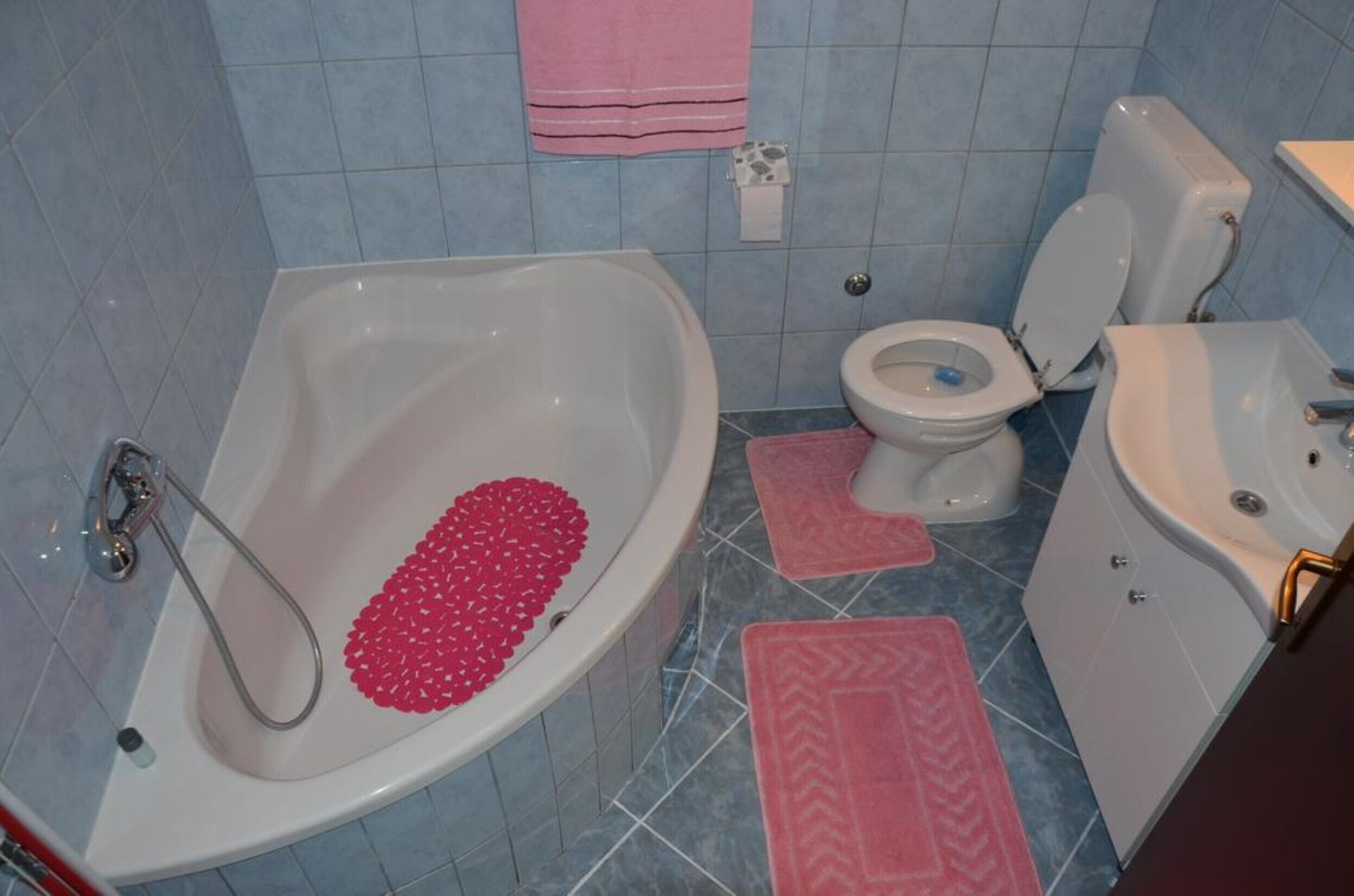 A bathroom with a bathtub, toilet, and sink.