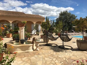 A courtyard with a pool, outdoor seating, and potted plants. - Little paradise, close to Arles, Provence, spacious terrace and pool (Arles)